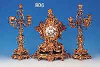 DEKORATIVE KAMINUHR MIT 2 KERZENLEUCHTERBEI- STELLERN, FRANKREICH, UM 1860, REICH VER- ZIERTER UND VERGOLDETER BRONZEGUß IM ROKOKO- STIL MIT ...