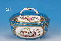Ovale Dekeldose, Sèvres, um 1790, Weich- porzellan blau glasiert und mit Golddekor, in Kartuschen feine bunte Malerei von exoti- schen ...
