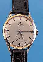 UNIVERSAL GENEVE HERRENARMBANDUHR, NEUTR. RG 750/000 GEH., BODEN U. GLASR. GEDR., D. CA.37 MM, GUILL. U. VERS. ORIG.-BLATT, RUNDANKER-WERK, 17 ...