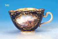 TASSE MIT UNTERTASSE, MEISSEN, UM 1880/90, ANSICHTSTASSE, KOBALTBLAUER GRUND, REICHE GOLDSTAFFAGE, IN ZWEI KARTUSCHEN ANSICHT VON RATHEN ...