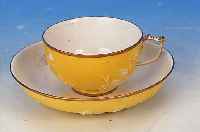 TASSE MIT UNTERTASSE, MEISSEN, UM 1720-25, PORZELLAN, GELBER FOND, MIT WEIßEM TEILRELIE- FIERTEM BLUMENDEKOR, GOLDSTAFFAGE, TASSENH. 5 CM; D. ...