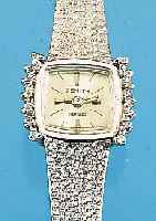 ZENITH DAMENGOLDBANDUHR, SCHWEIZ UM 1970, NEUTR. WG 750/000-GEH. INCL. WG-BAND RODH., LüNETTE SEITL. M. 14 8/8 DIAMANTEN ZUS. CA. 0,2 CT ...