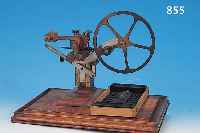 UHRMACHERMASCHINE, SOG. WäLZMASCHINE, UM 1900, AUF HOLZSOCKEL MONTIERT, STAHL/MESSING, 3 SCHLITTEN, HANDSCHWUNGRAD MIT SPANNROLLE, LEICHTE ...