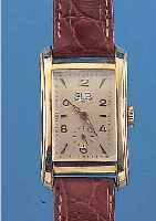 GUB HERRENARMBANDUHR GüTEKLASSE I, DEUTSCH- LAND UM 1955, METALL GELBVERG., SELTENE GEH.- FORM, TAILL. ANGED., EDELST.-BODEN GEDR., IN SICH L. ...