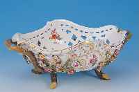 HENKELSCHALE IN FORM EINES KORBES, MEISSEN, UM1860-80, PORZELLAN, AUF VIER FüSSEN STEHEND,WANDUNG IM DURCHBRUCHARBEIT, REICH MIT BUNTEN VOLLPLAST. ...