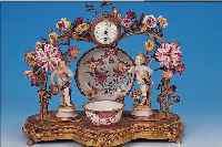 KAMINUHR, FRANKREICH, UM 1870, SPIRTZGUßMONTUREN MIT BUNTEN PORZELLANBLüTEN (DIESE TEILS BEST.), KOPPCHEN UND TELLERCHEN CHINA, ...