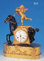 PENDULE, FRANKREICH, UM 1830, VERZIERTER UNDVERGOLDETER BRONZEGUß, IM SOCKEL MIT SPIELEN- DEN PUTTOS, VOLLPLASTISCHER SCHWARZ GEFAßTER ...