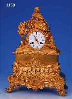PENDULE, FRANKREICH, UM 1830/1840, VERZIER- TER UND VERGOLDETER BRONZEGUSS, IM SOCKEL MIT ROCAILLEN U. SEITLICHEN FüLLHöRNERN, BEKRöNUNG ...