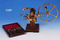 UHRMACHER-WERKZEUG, DEUTSCH, UM 1900, SOGEN.WäLZMASCHINE AUF ORIGIN. NUSSBAUMSOCKEL MONTIERT, STAHL/MESSING/BRONZE, SYSTEM ...