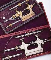 KONVOLUT: UHRMACHERWERKZEUG, 2 ZAPFENROL- LIERMASCHINCHEN IM ETUI, BEIDE M. SOGEN. FIEDELBOGEN, NUTZSP., BEIDE UM 1914, EINSäTZE NICHT ...