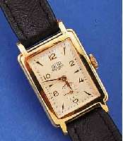 GUB HERRENARMBANDUHR, DEUTSCHLAND UM 1956, METALL HARTVERG., EDELST.-BODEN GEDR., ORIG.- BLATT ALTERSBED. L. FL., FORMANKERW. M. IND. KL. SEK., 15 ...