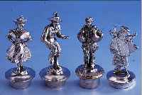 KONV. 4 ZIERKORKEN, DEUTSCH UM 1900, METALL VERSILBERT, VERSCH. DARSTELLUNGEN: 2X TANZENDES PAAR/TRACHT, 1X HANS IM GLüCK, 1X FLACHE ...