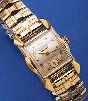 BENRUS HERRENARMBANDUHR, SCHWEIZ/USA UM 1950, GG-FILLED, AUFWEND. RECT.-FORM, SCHEREN-GLIEDERB. SPäTER, KONKAVGL. 3-FLäCHIG, VERS. BLATT FL., ...