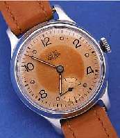 GUB HERRENARMBANDUHR, DEUTSCHLAND UM 1955, METALLGEH. VERCHR., BER., EDELST.-BODEN U. GLASR. GEDR., ORIG.-BLATT FL., KAL. 60, 15 ST.HANDAUFZUG, ...