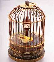 TISCHUHR IN FORM EINES VOGELKäFIGS, VOGEL BEWEGL., KUGELFöRM. ZEITANZ., IM BODEN BEF. STIFTENANKERW., AKTUELLE PROD., MESSING, TEILW. ...