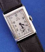 OMEGA HERRENARMBANDUHR, SCHWEIZ UM 1938, EDELST., RECT.-FORM, BODEN GEDR., BLATT M. EMAILL. STD.-ZEICHEN REST., FORMANKERW., 15 ST., KAL. ...