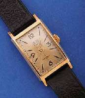 GUB HERRENARMBANDUHR, DEUTSCHLAND UM 1957, METALL ROSEVERG., EDELST.-BODEN GEDR., RECT.- FORM IN SICH GEW., ORIG.-BLATT VERS., ALTERS- BED. FL., ...