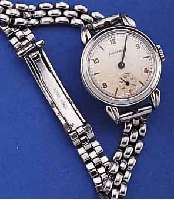 MOVADO DAMENARMBANDUHR, SCHWEIZ UM 1942, EDELST., BODEN GEDR., VERS. BLATT, ALTERSBED. L. FL., GEBL. STAHLZEIGER, RUNDANKERW., KAL. 105, 15 ST., ...