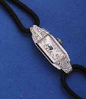 ART-DEART-DECO DAMENARMBANDUHR, SCHWEIZ UM 1938, WG 585/000 RHOD., SCHARNIERBODEN, ZU DEN KORDELBANDANST. 12 8/8 DIAMANTEN, BLATT REST., BEZ. ...