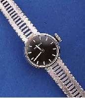 DUGENA DAMENGOLDBANDUHR, DEUTSCHLAND UM 1968, WG 585/000-GEH. INCL. BAND RHOD., BODEN GEDR., SCHWARZES KONTRASTZIFFERBL., FORMANKER- W., 17 ST., ...