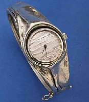 DESIGNER DAMENARMBANDUHR AUS GEGOSSENEM UND GETRIEBENEN 925ER SILBER, QUARTZWERK EINGEL. IN EINEM TEIL DER BEIDE HALBSPANGEN, 2 SICHER- HEITSACHTEN, ...