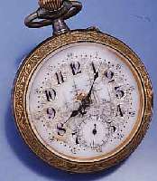 ÜBERGROßE HERRENTASCHENUHR, SCHWEIZ UM 1915, EISEN BRÜN., GLAS U. BODENRAND MESSING, RELIEF. DARST. VON BLÜTEN U. BLÄTTERN, EMAIL- BL. DEFEKT, ...