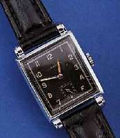 JUNGHANS HERRENARMBANDUHR, DEUTSCHLAND UM 1942, GR. RECT.-FORM, MAßE CA. 39 X 26 MM, METALL HARVERCHR., EDELST.-BOD. AUFGEDR., SCHWARZES ORIG. ...