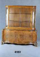 Vitrinenschrank, deutsch, um 1928/30, z.T. Nußbaum massiv, Kaukasisch Nußbaumfurnier, ge- spiegelt, qualitÄtvolle Intarsien in Birke, ...