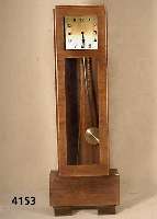 Standuhr, deutsch, um 1928/32, Korpus Weich- holz/Hartholz, einfacher wuchtiger Aufbau, kaukasisch Nußbaum querfurniert, Werk mit 2 Gewichten, ...