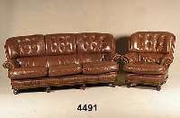 Sitzgarnitur, wohl deutsch, um 1960, Leder, bestehend aus Sofa und 2 Sessel, RÜcken ge- heftet und genoppt, lose Kissen, Schauteile Nußbaum ...