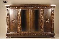 PrunkbÜcherschrank, deutsch, um 1910, Nuß- baum massiv, Nußbaumfurnier, Weichholz, 4-tÜrig, davon 2 facettiert verglast, reiche Blatt- und ...