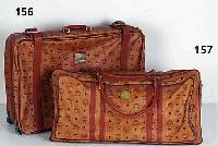 MCM-Koffer, typ. MCM-Dekor mit braunem Leder abgesetzt, 2 Rollen, Nr. 42794, 2 SchlÜssel, stÄrkere Gebr.-Spuren, ca. 68 x 48 cm