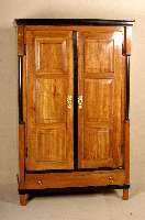 Biedermeierschrank, deutsch, um 1840, Kirschholz massiv, die beiden kassettierten TÜren werden seitlich flankiert von eingestel- lten schwarzen ...