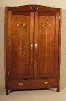 Schrank, wohl deutsch, um 1910, Nußbaumfur- nier, zweitÜrig, Sockelschublade, in den TÜren und im oberen Abschluß floral stilisierte Intarsien ...
