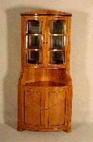 Eckschrank, im Biedermeierstil, nach dem Vorbild von 1820/30, Kirschbaum massiv, unter Verwendung Älterer Teile, Oberteil verglast, z.T. schwarz ...
