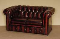 2-sitzer Sofa, England, Chesterfield, roter Lederbezug, genoppt und geheftet, auf Rollen, lose Kissen, leichte Gebrauchsspuren, ca. 71x138x82 cm, ...