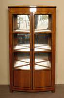Eckvitrine, im Biedermeierstil, Kirschbaum massiv, nach dem Vorbild von 1820/30, unter Verwendung alter Teile, verglast, z.T. schwarz gelackt, ...