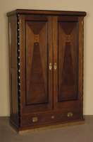 Schrank, um 1925/30, Eichefurnier mit Intarsien in verschiedenen HÖlzern, zweitÜriger Korpus mit Sockelschublade, Inneneinrichtung mit ...