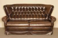 Ledersofa, im englischen Stil, wohl um 1970, braunes Rindsleder, RÜckenlehne geheftet und genoppt, lose Kissen, Gebrauchsspuren, ca. 89x166x88 cm, ...