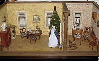 Puppenstube mit zwei Zimmern, um 1900, reiche Einrichtung, Stofftapeten, mit Bollerofen, Weihnachtsbaum, Bildern etc., dazu zwei PÜppchen, ca. ...