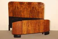 ArtDeco-Bett, Frankreich, um 1920, in kaukasisch Nußbaum gespiegelt furniert, zum Teil schwarz abgesetzt, Fußteil in elegantem Schwung dreifach ...