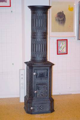Grosser gußeiserner Ofen, um 1850/60, reich verziert mit Mäanderband, floralem Dekor u.Löwenmaskeronen, H.ca.185cm, weisse Porzellanknöpfe an den ...