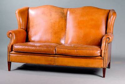 Ledersofa, wohl deutsch, 50er Jahre, Ohrenform, seitlich in Ohrenform auslaufend, Leder mit Patina, Gebrauchsschäden, 98 x 155 x 82 cm, Sh. 47 cm, ...