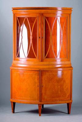 Eckvitrine, deutsch, um 1930, Mahagoni, Unterteil 2-türig, 4 Beine, konisch verlauf., Ahornfadenintarsien, Oberteil verglast, Kopf getreppt, 2 ...