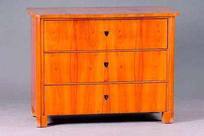 Kommode, Biedermeier, um 1835, Kirschbaum, 3-schübig, orig. Beschl., Ecken abgeflacht, schwundrissig, Platte fleckig, st. Gebr.-Sp., SP. 1200,-, ca. ...