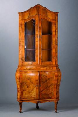 Barockaufsatzvitrine, Anfang 20. Jh., Nußbaumfurnier, Unterteil 2-türig, bombiert, Oberteil 2-türig, verglast, allseitig geschweift, sparsame ...