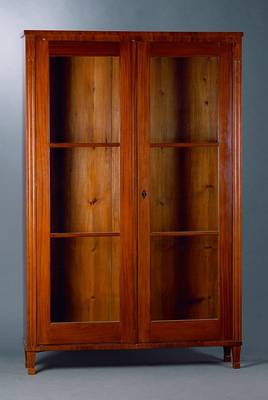 Bücherschrank, Berlin, um 1830/40, Mahagoni, im Schinkelstil, 2-türig, verglast und versprosst, Lisenen gerieft, Furnierteile fehlen, Füße sek., ...