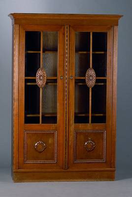 Bücherschrank, wohl Karlsruhe, um 1910, Eiche, reiner Jugendstil, teils facett. verglast, 2-türig, versprosst, ausgesetzte Schnitzereien, 4 ...