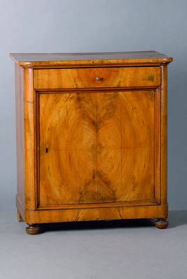 Kommode, deutsch, um 1830/40, 1 Tür 1 Schublade, abgerundete Ecken, Nußbaum, Furnierschäden, st. Gebr.-Sp., alt belassen, Tür in Rahmenfüllung, ...