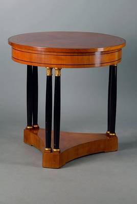 Runder Tisch, wohl Stuttgart, um 1905/10, Kirschbaum, feistehende Säulen geschwärzt, teilsgoldfarbene Abschlüsse, schwarz intarsiert, Polsterung ...